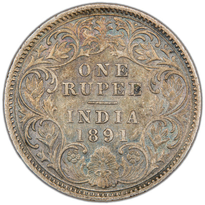 Reverse of a British India 1891 One Rupee silver coin (Calcutta mint, SKU: SP2907), displaying the denomination ONE RUPEE and date 1891 above INDIA across four lines, framed within an intricate floral scroll wreath design.