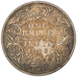 Reverse of a British India 1893 One Rupee silver coin (Bombay mint, SKU: SP2908), displaying the denomination ONE RUPEE and date 1893 above INDIA across four lines, featuring the incuse dot mintmark of the Bombay mint, framed within an intricate floral scroll wreath design.